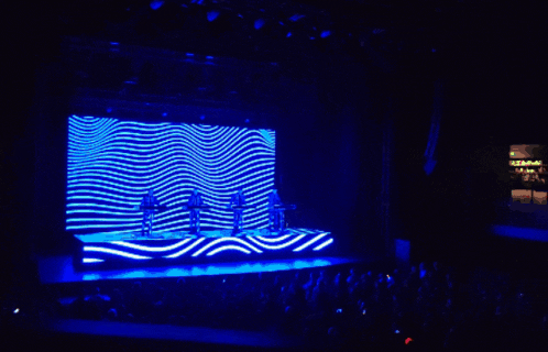 a group of people on a stage in front of a large screen
