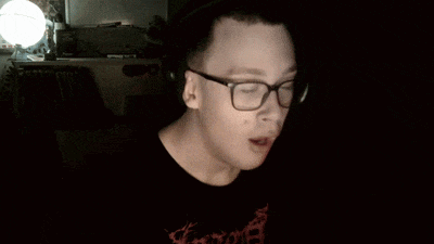 a man wearing a shirt that says ' slayer ' on it waves his hand