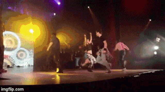 a group of people are dancing on a stage with the url imgflip.com