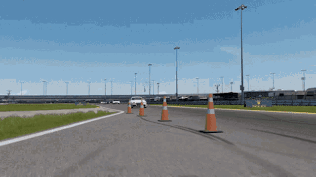a row of orange and white traffic cones on a race track