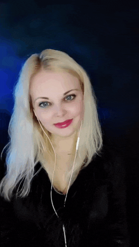 a blonde woman wearing headphones and a black jacket