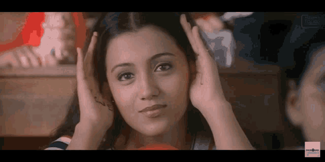 a close up of a woman covering her ears with her hands with a watermark that says ' indiatimes ' on it