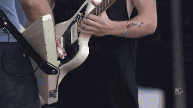a man playing a guitar with a tattoo on his arm that says ' i 'm the king of the world '