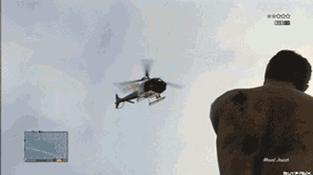 a helicopter is flying over a person holding a gun