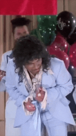 a woman in a light blue suit is dancing