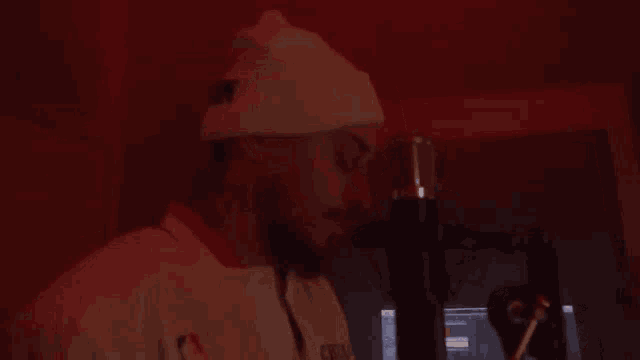 a man wearing a white hat with the word ny on it stands in front of a microphone