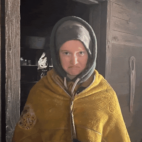 a person wearing a yellow hoodie with a clock on the front