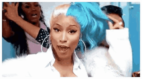 a woman with blue hair is standing in front of a group of people .
