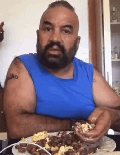 a man with a tattoo on his arm is eating a meal