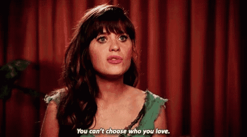 a woman is standing in front of a red curtain and saying `` you can 't choose who you love '' .
