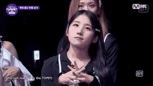a girl with her eyes closed in front of a sign that says mnet 999