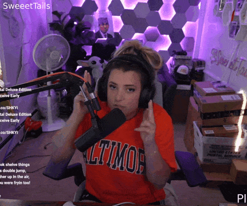 a woman wearing headphones and a red shirt that says altimor