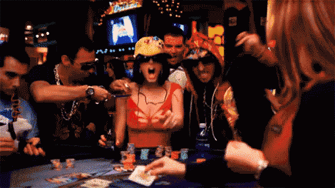 a group of people are playing poker at a table with a woman wearing a red top and sunglasses