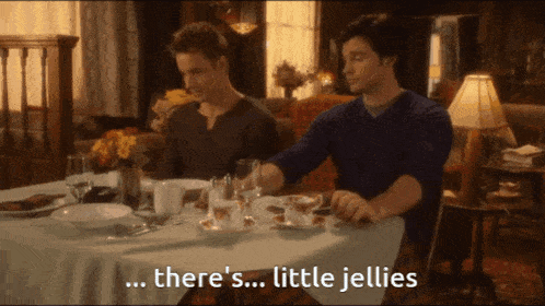 two men sit at a table with the words " there 's little jellies " on the screen