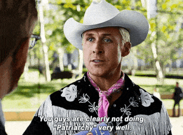 a man wearing a cowboy hat and a pink scarf says you guys are clearly not doing patriarchy very well .