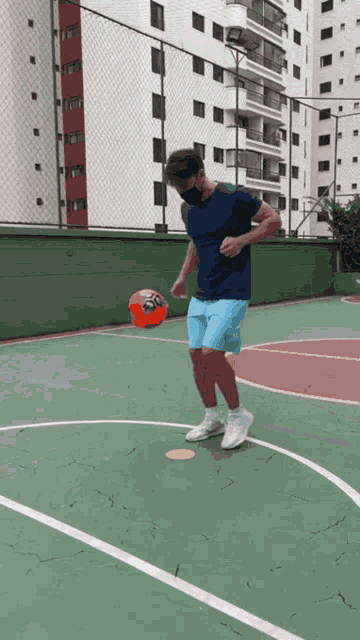 a man wearing a mask kicks a ball on a basketball court
