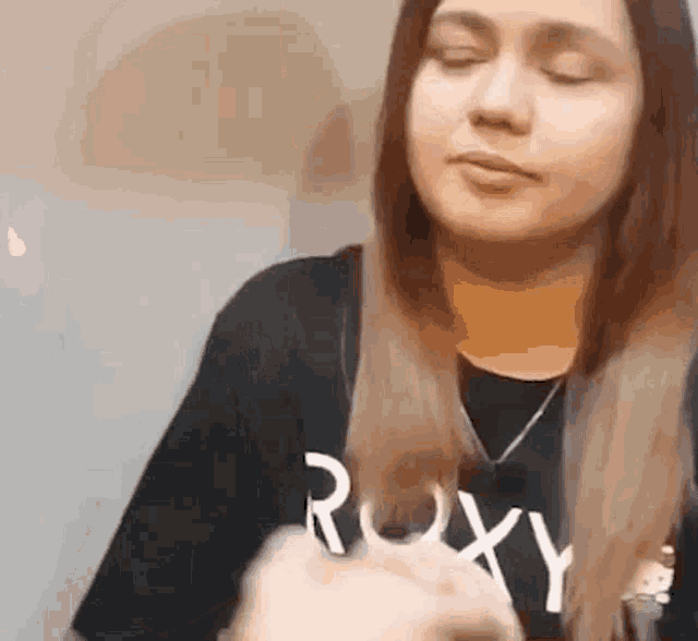 a woman wearing a black shirt with the word roxy on it .