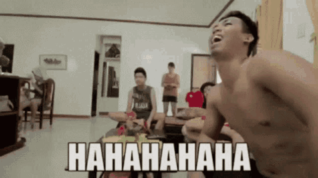 a shirtless man is laughing in a living room with the words hahahaha written on the bottom right