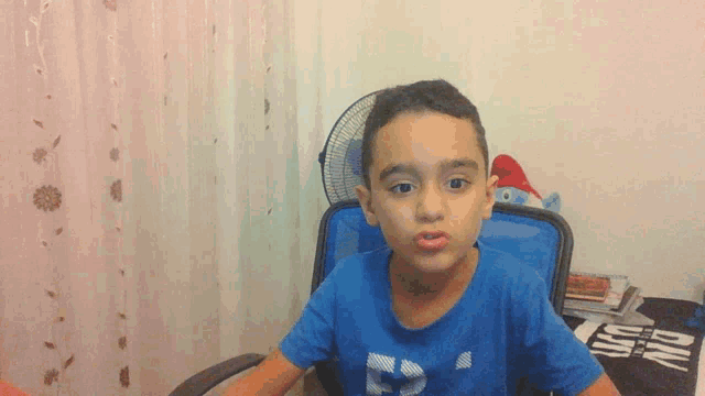 a young boy wearing a blue shirt that says f on it