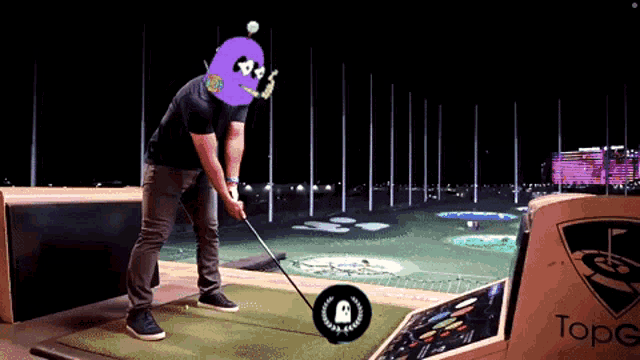 a man is swinging a golf club in front of a sign that says topgolf