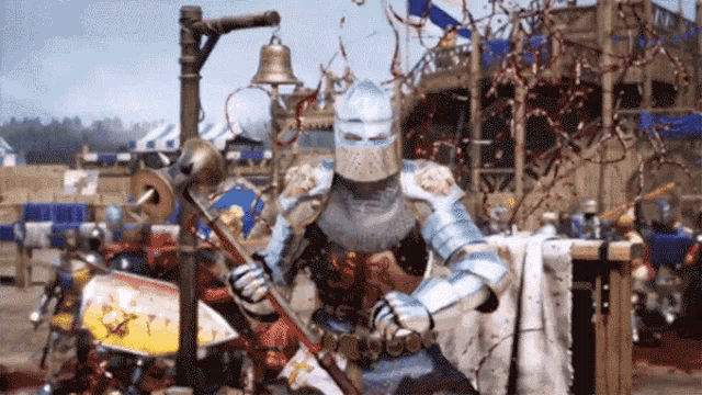 a knight in armor is holding a sword in front of a crowd