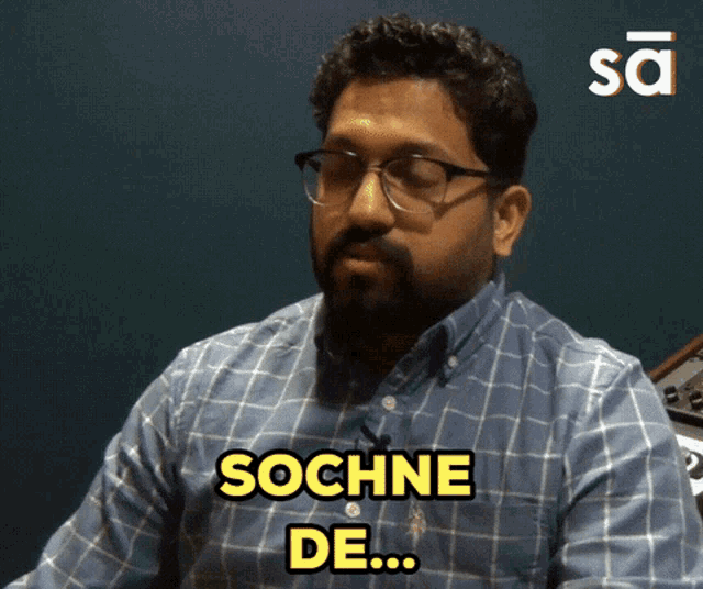 a man wearing glasses and a blue shirt says sochne de