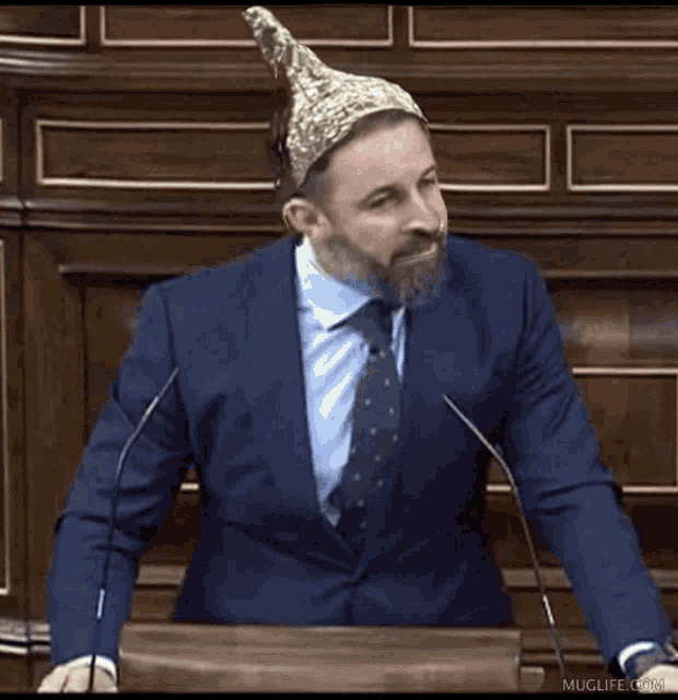 a man in a suit and tie stands at a podium with the words yo colecciono written below him