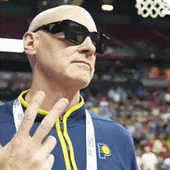 a bald man wearing sunglasses and a blue jacket with the letter p on the front