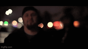 a man is lighting a cigarette with a lighter in the dark while looking at his phone