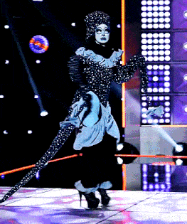 a woman in a black and white polka dot dress is on a stage