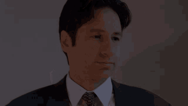 a man in a suit and tie is looking to the side