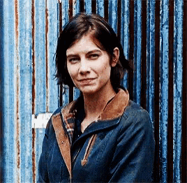 a woman standing in front of a blue wall