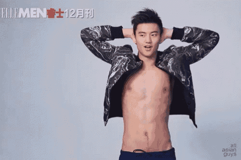 a man without a shirt is standing with his hands behind his head in front of a sign that says all asian guys