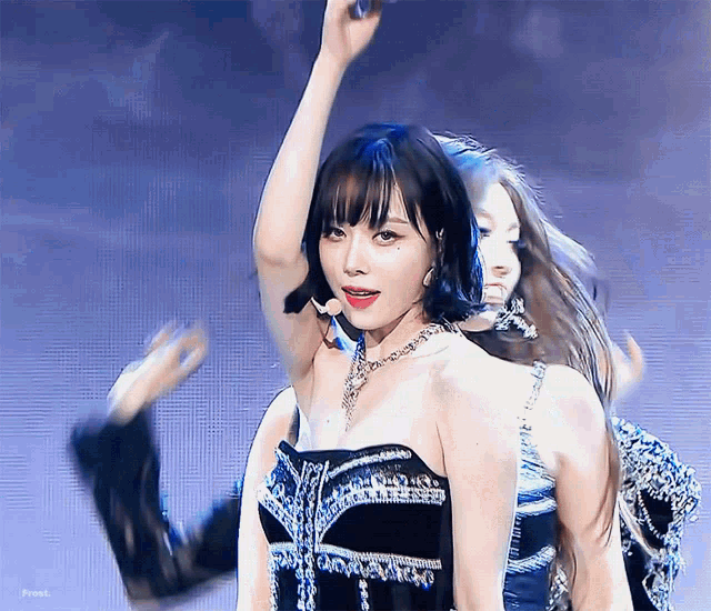 a woman in a black and blue dress is dancing