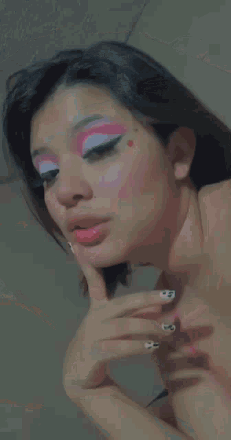 a close up of a woman 's face with pink and white makeup on .