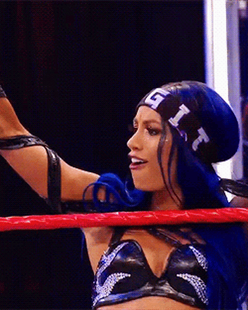 a woman with blue hair wearing a headband with the letters g and r on it