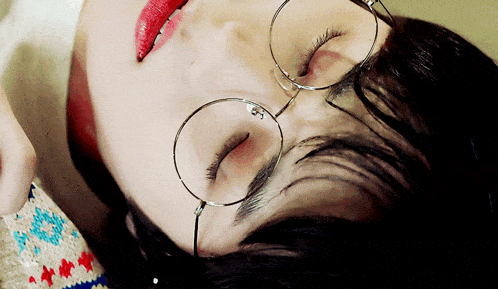 a close up of a person wearing glasses and red lipstick