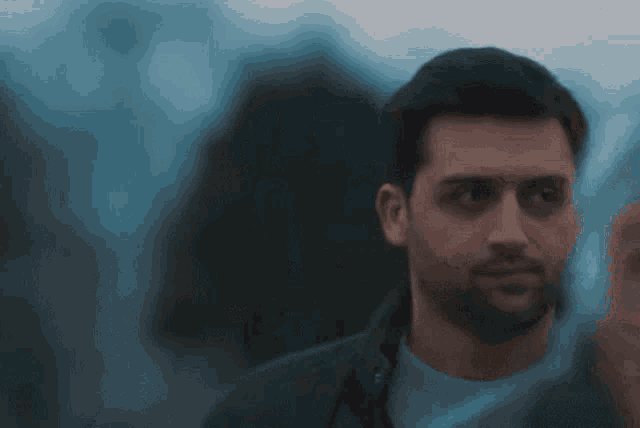 a man with a beard is wearing a blue shirt