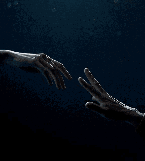 a person 's hand is reaching out towards another person 's hand