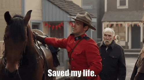 a man in a red uniform is petting a horse and says saved my life