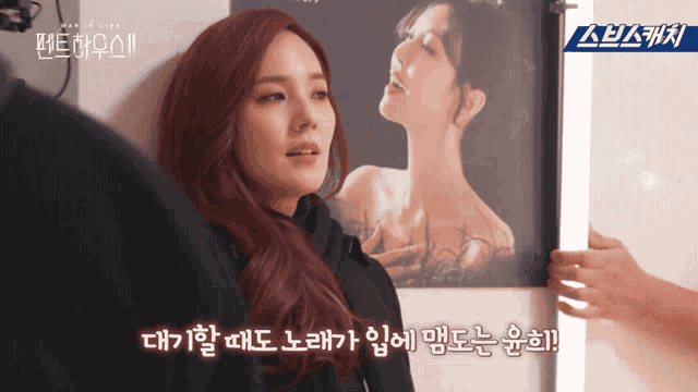 a woman with red hair is standing in front of a picture of a woman with chinese writing behind her