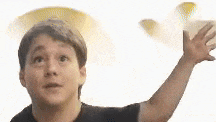 a young man is throwing a frisbee in the air while looking up .