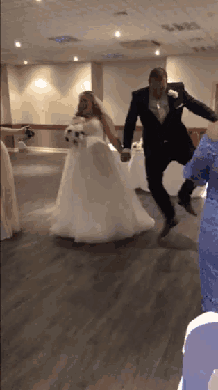 a bride and groom are jumping in the air holding hands