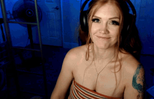 a woman wearing headphones and a striped top smiles
