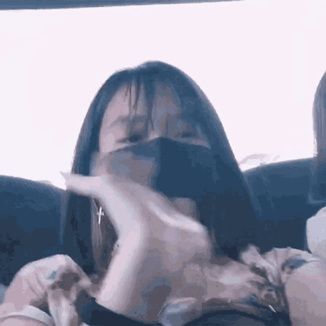 a woman wearing a face mask is sitting in a car .