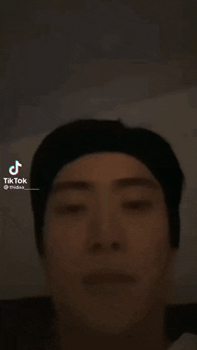 a close up of a man 's face with a tik tok logo on the bottom