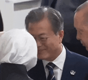 a man in a suit and tie is standing next to a woman in a white hijab .