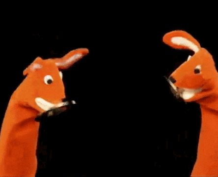a couple of stuffed animals are standing next to each other and looking at each other .