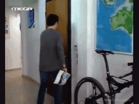 a man standing in a hallway with a mega logo on the wall