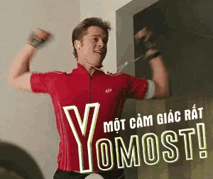 a man in a red shirt is flexing his muscles in front of a sign that says yomost!